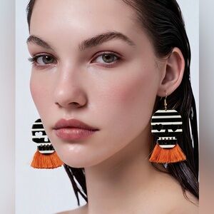 Plunder skeleton dangle skulls accented with orange tassels earrings